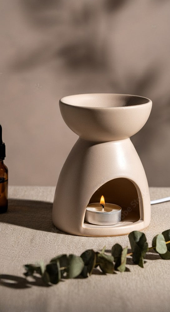 Diffuseur artisanal sur une console en bois, entouré de plantes et d’objets décoratifs naturels.