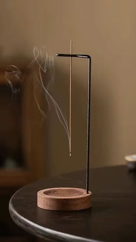 Porte-encens en bois naturel avec un bâton allumé dans une ambiance apaisante