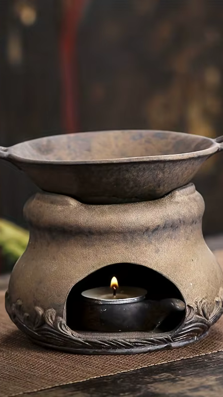 Diffuseur à chaleur douce avec bougie allumée, diffusant une ambiance chaleureuse dans un intérieur zen.