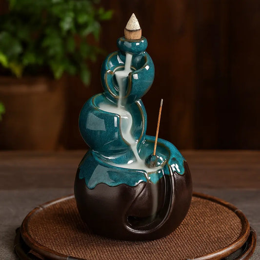Brûleur d’encens en céramique turquoise et marron avec cascade à reflux et porte-bâton intégré sur fond bois et ardoise